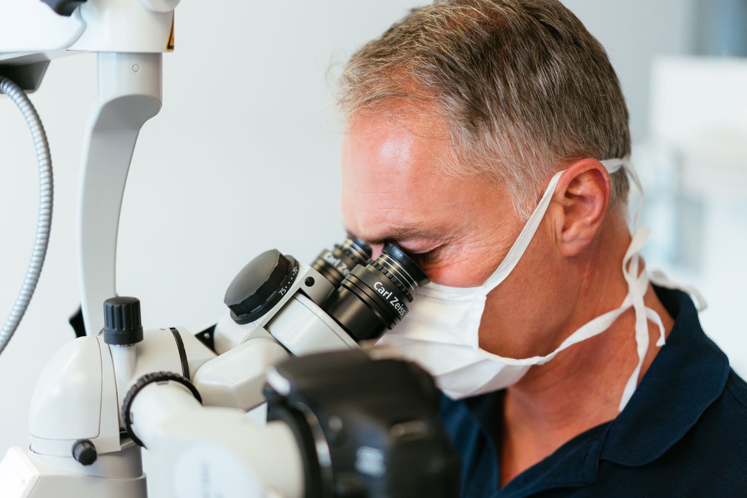 Dr. Stöcker arbeitet am Dentalmikroskop