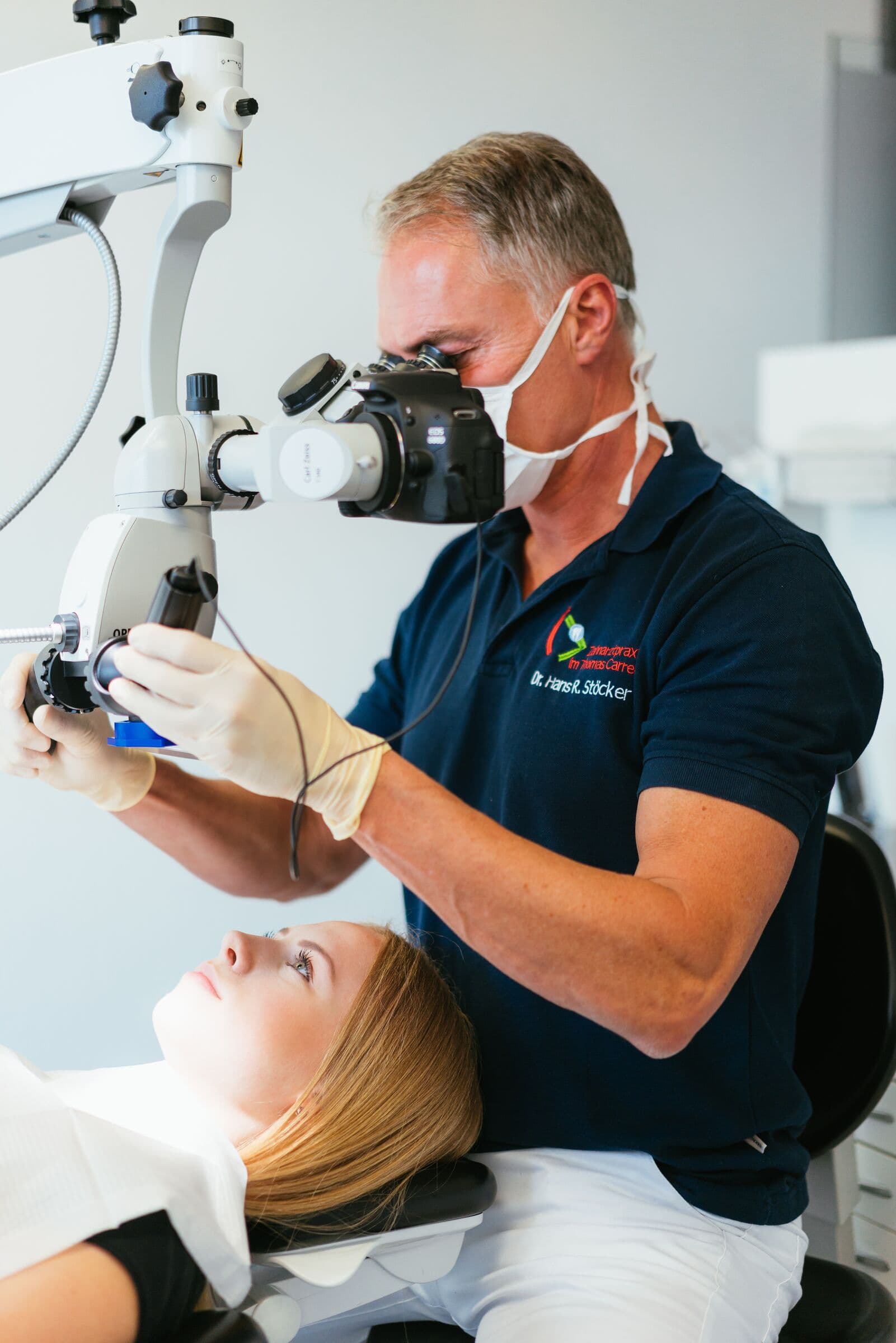 Dr. Stöcker behandelt eine Patientin am Dentalmikroskop